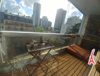 Sunlit balcony with city views and cozy seating
