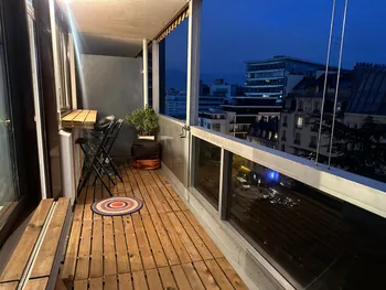 Twilight balcony with wooden deck and city glow