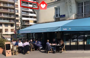 Balcony with metal railing overlooking café street